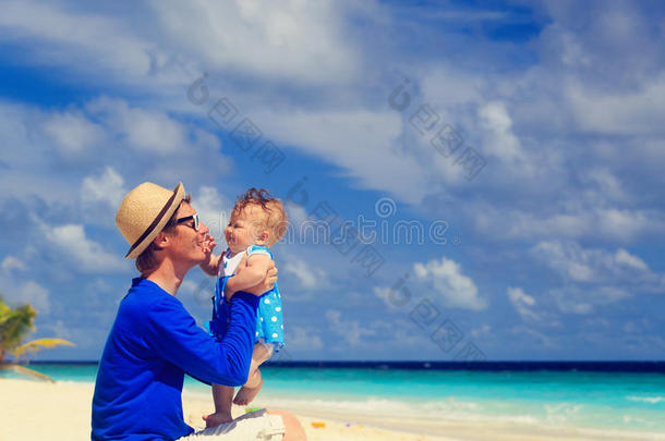 父亲和可爱的小女儿在海滩玩