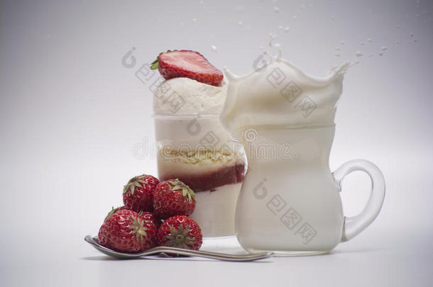 新鲜草莓掉进甜点附近飞溅的牛奶里