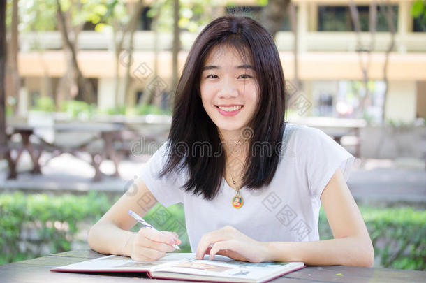 亚洲泰国中国学生大学美丽的女孩写了一本书。