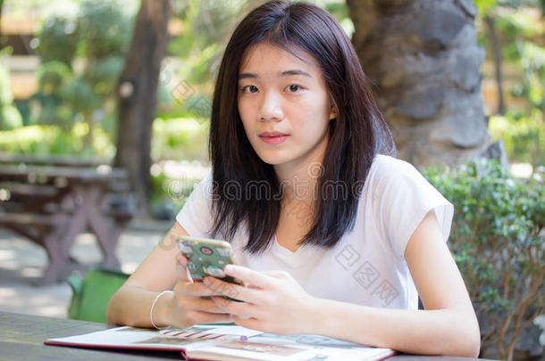 亚洲泰国中国学生大学美丽的女孩使用她的智能手机。