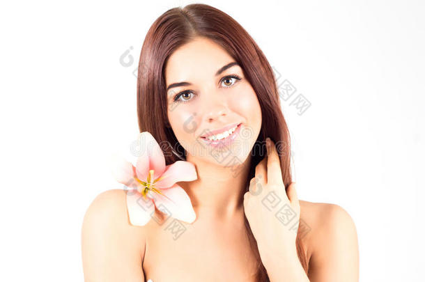 美丽的水疗女人抚摸她的头发。 有粉红色花朵的女人带着洁白的牙齿<strong>微</strong>笑。 皮肤<strong>清新</strong>清澈的女人。