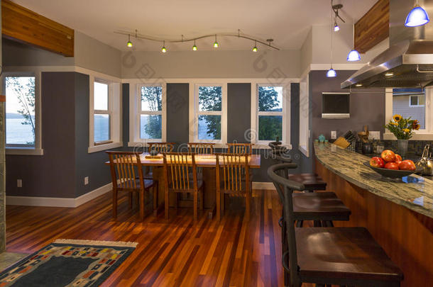 餐厅和厨房早餐吧与木地板和花岗岩台面在当代高档家庭内部