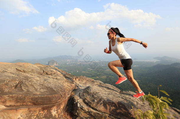 亚洲女子跑步者在山峰上跑步