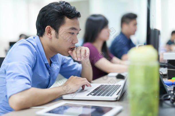 亚洲商人坐在办公桌前工作笔记本电脑业务