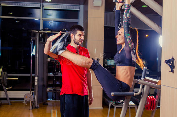 健身，运动，训练和人的概念-私人教练帮助妇女与腹部肌肉按压