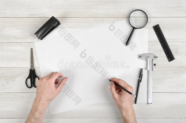 特写的手，男人拿着铅笔，在白纸上画在的视图。 绘图员工作场所配备尺子、钢笔
