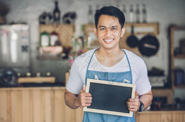 亚洲男咖啡馆老板带空白板