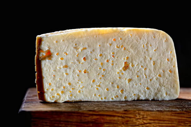 黑色背景上木板上的一块奶酪