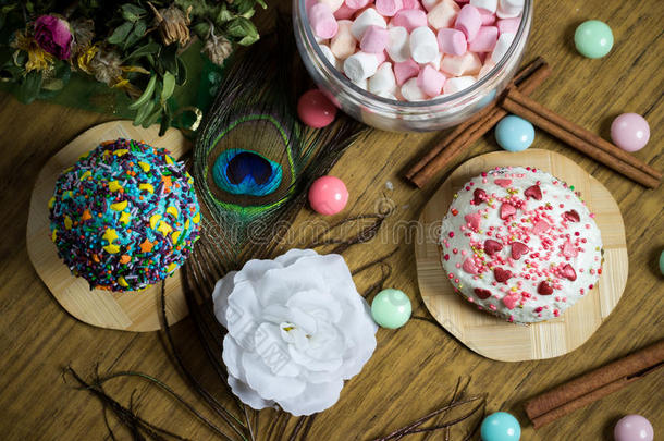 庆祝甜蜜的纸杯蛋糕，肉桂装饰，羽毛，糖果，花生日派对