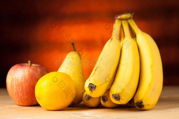 桌子上的水果-香蕉、梨、苹果和柠檬是木制的