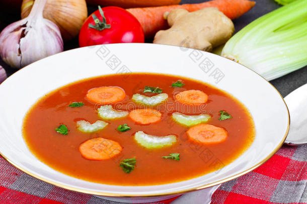 胡萝卜番茄<strong>汤</strong>在盘子里。 躺在<strong>汤料</strong>后面，