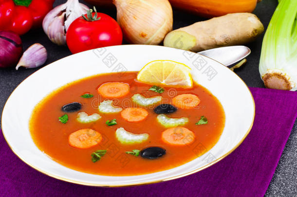 胡萝卜番茄汤在盘子里。 躺在汤料后面，