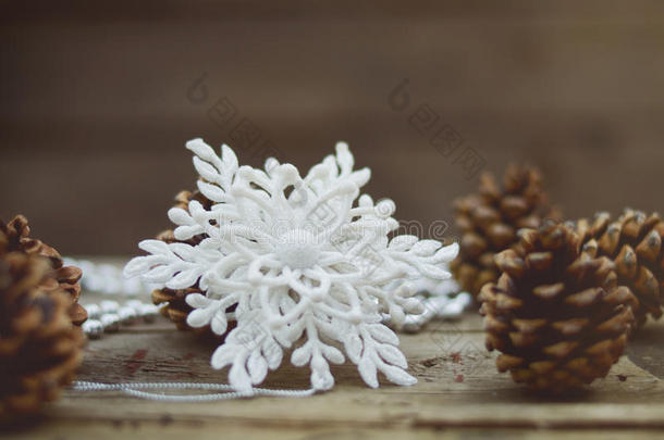 圣诞节，冬天背景白色雪花，松果在古老的木制表面。 复古和柔和的焦点图片