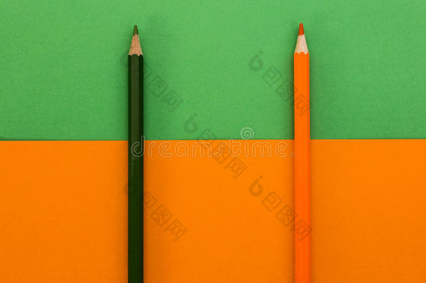 绿色和橙色背景上的黑色和橙色铅笔