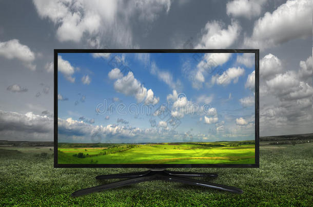 绿色草地上的4K现代<strong>电视</strong>，更多地显示颜色