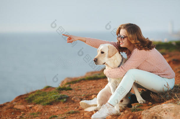 美丽的女孩和她的狗在海边