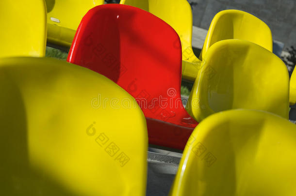特写镜头在体育场拍摄了大量的黄色和一个红色的塑料座椅