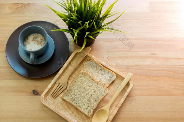 木桌上有面包早餐的杯子汤