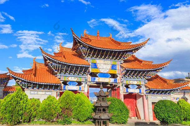 蓝天下中国寺庙的拱形入口和白色的克劳