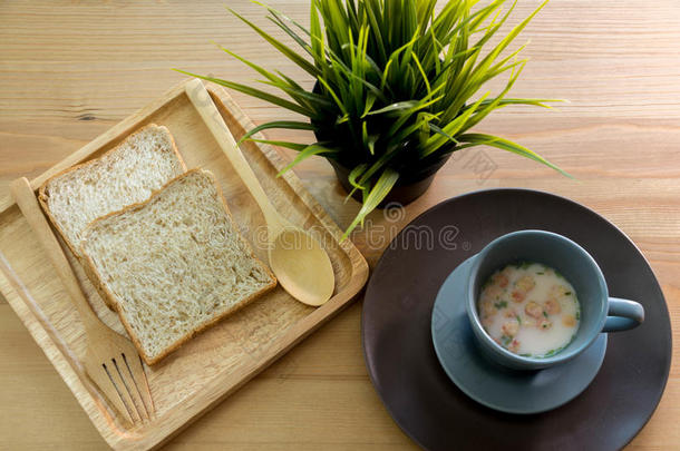 木桌上有面包早餐的杯子汤