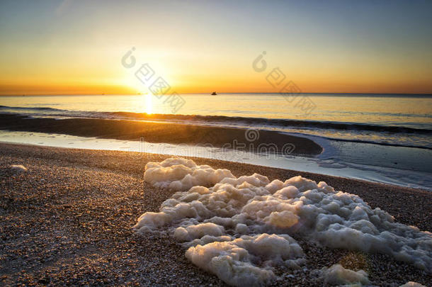 五彩缤纷的日出在海上，海上泡沫在岸上