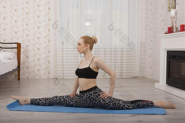 美丽的年轻女子练习瑜伽伸展在<strong>垫子</strong>上做分裂