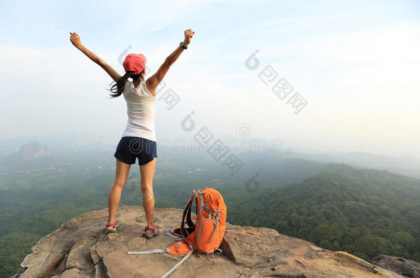 欢呼的年轻亚洲女徒步旅行者张开双臂