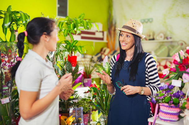 花<strong>店招</strong>待女顾客在商店买花。