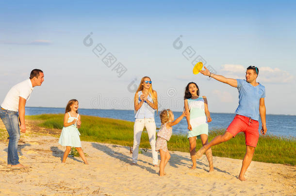 和孩子们在海滩上玩飞盘的朋友