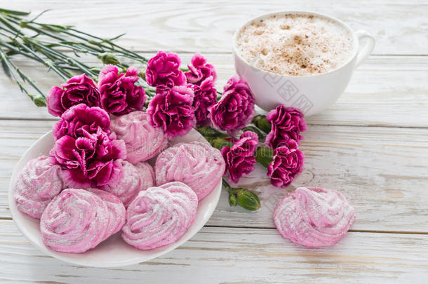 卡布奇诺和自制<strong>棉花糖</strong>甜点，木制桌子上的粉红色康乃馨