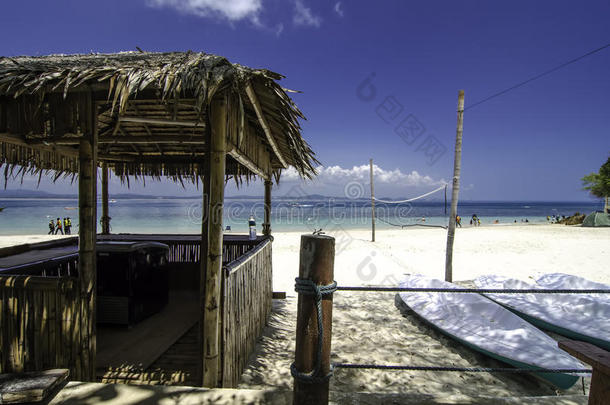 美丽的热带海景在卡帕斯岛，马来西亚。竹屋和皮艇。白色的沙滩和清澈的水与蓝天