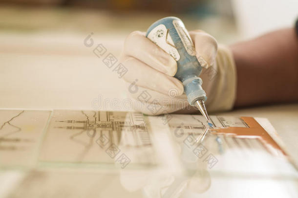 特写手工工人手使用绘画工具玻璃应用色彩装饰