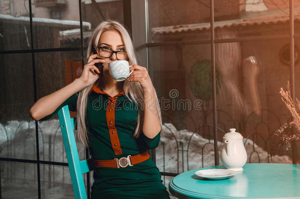 商务女士在咖啡休息时间打电话喝茶