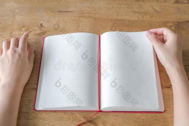 双手打开空白目录，杂志，书模拟在木桌上。