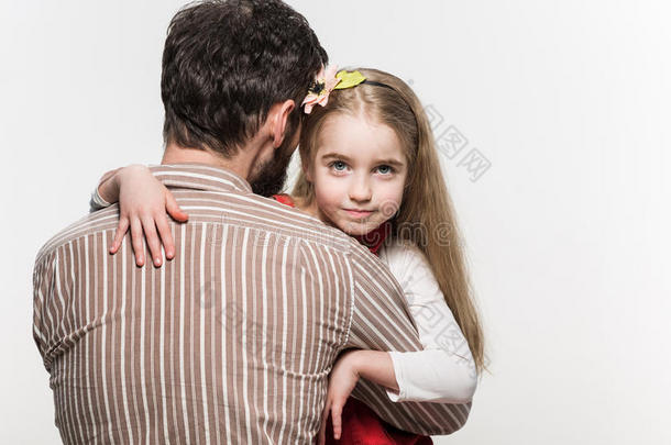 女孩在白色背景下拥抱她父亲