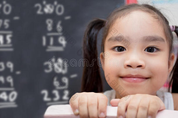 女孩用粉笔在黑板上画数学计算