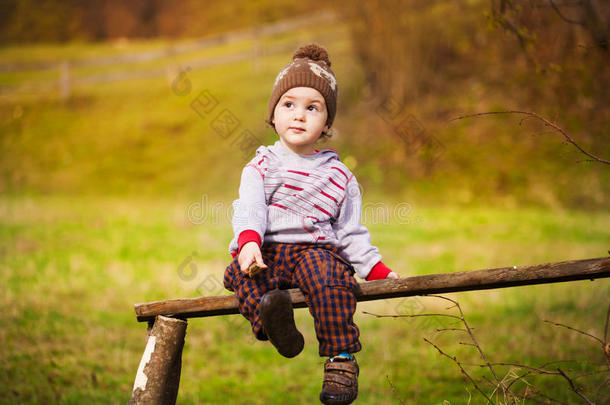 一个小男孩坐在树下。