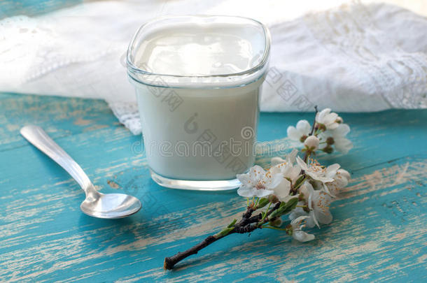 一杯天然酸奶，一枝樱花，一张白色花边亚麻餐巾