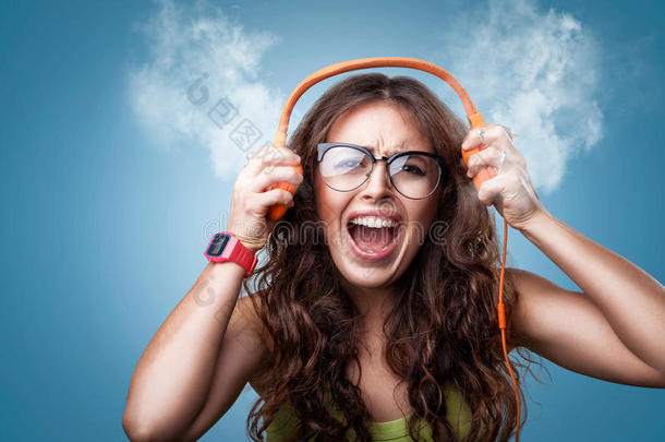 愤怒的疯狂女孩戴着耳机听音乐。