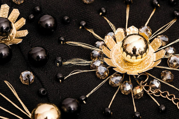 绣着水晶和黑色珠子的金色花朵
