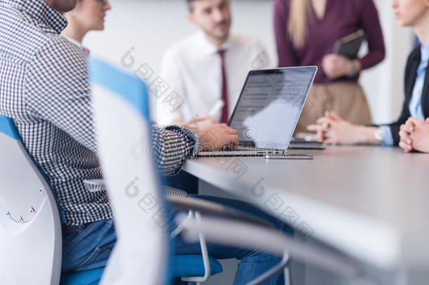 关闭商务人员，双手在笔记本电脑上打字，团队在后台开会