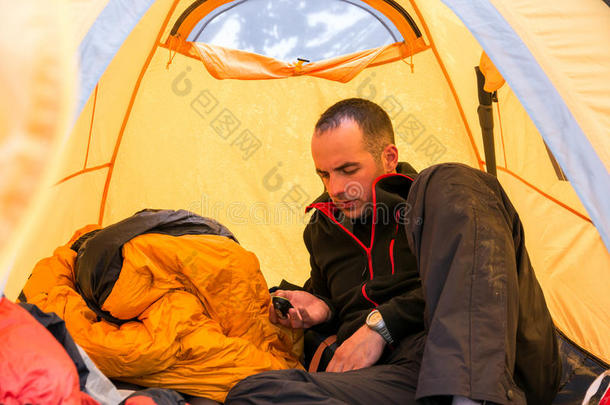 登山者在露营帐篷内使用小工具