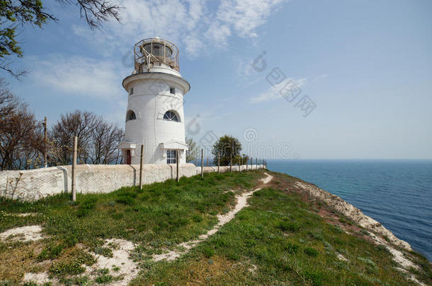 美丽的白色灯塔在海上海岸线上。 夏天的海景