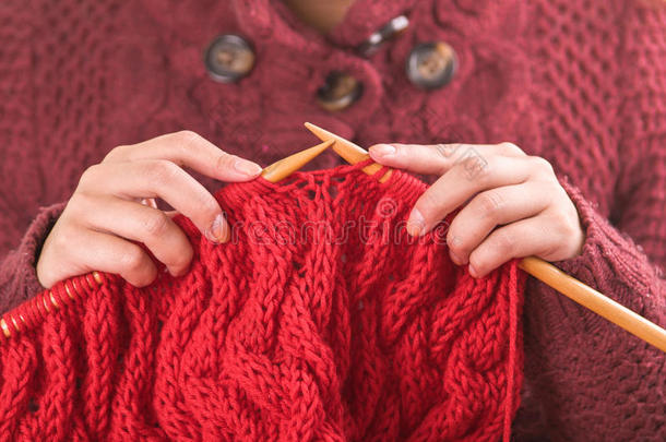 特写妇女的手拿着木制编织针，在红领巾上工作