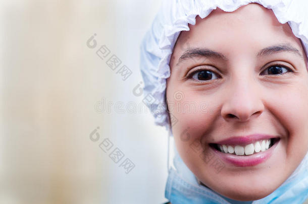 特写镜头，女护士戴着蓬松的帽子，为相机高兴地微笑