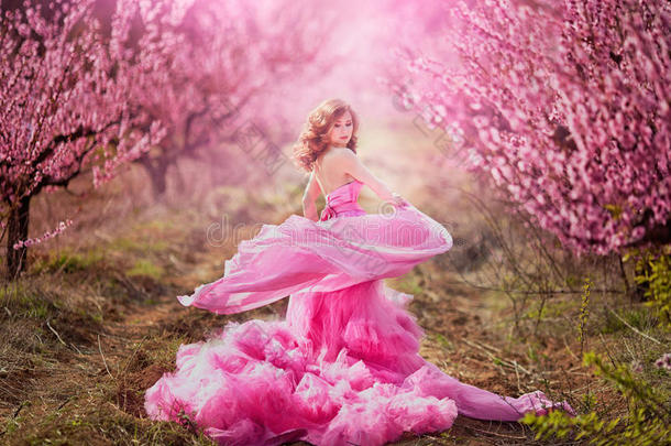 <strong>桃园</strong>里穿着粉红色连衣裙的漂亮女孩
