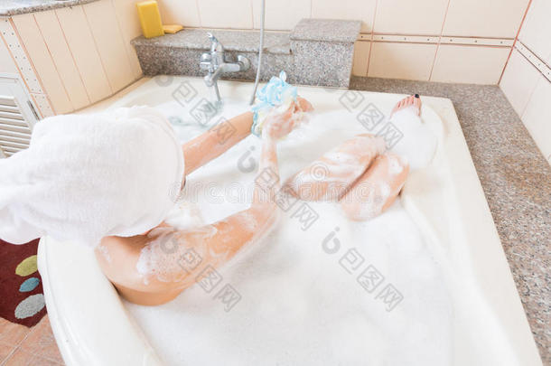 漂亮的女孩在浴缸里洗澡和洗手。