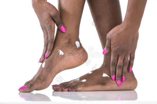 特写非洲妇女在光的背景下在<strong>脚上</strong>涂润肤霜