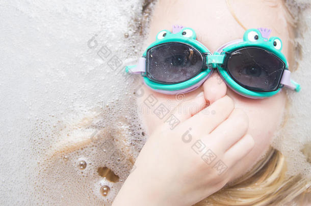 带潜水镜的女孩在浴缸里潜水