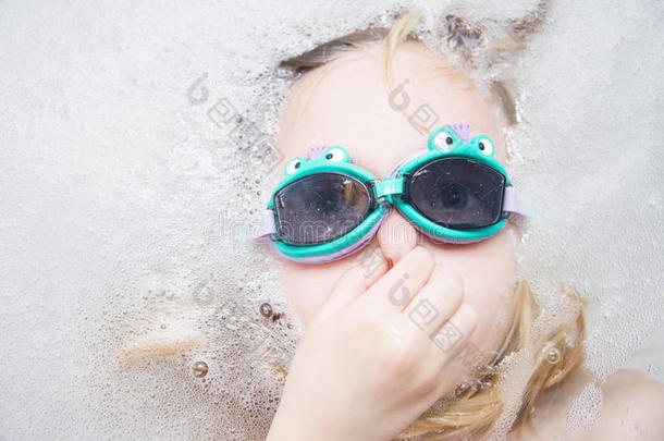 带潜水镜的女孩在浴缸里潜水